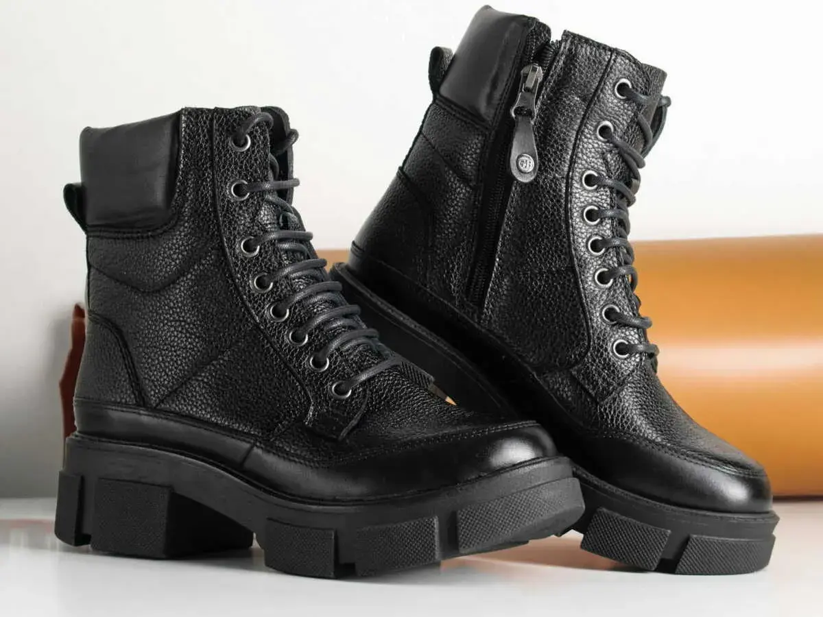 Paire de bottes noires en cuir texturé, parfaites pour un entretien facile. Ces bottes à lacets et fermeture éclair sont prêtes pour toutes vos aventures.