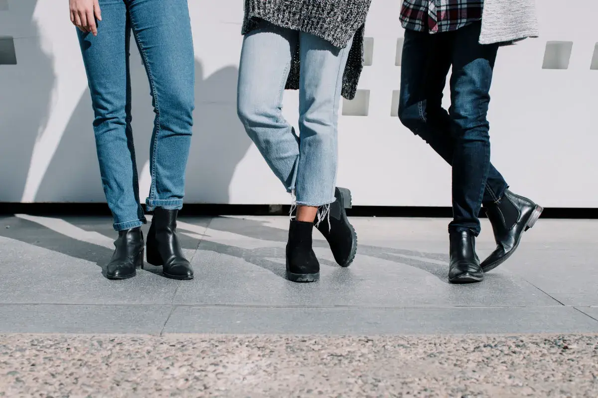 Trois paires de jambes portant des jeans et des bottes, un look décontracté et stylé.