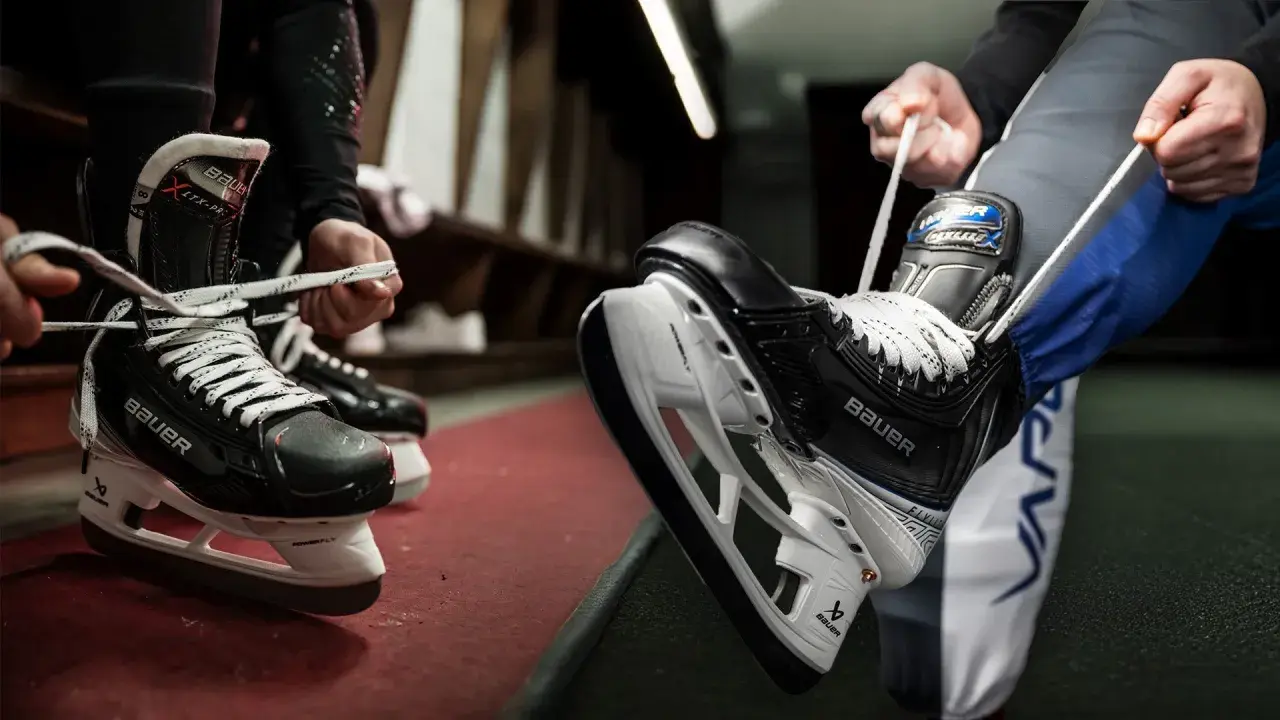 Des patineurs se préparent à entrer sur la glace, ils commencent à **poser soi même patin chaussure** pour le match.