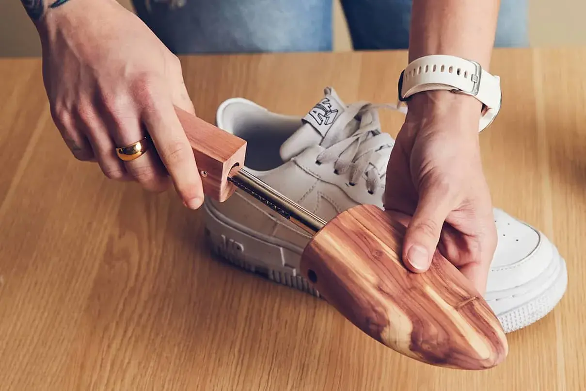 Utilisez un embauchoir en bois pour comment enlever les plis des chaussures. Il maintient la forme et absorbe l'humidité.