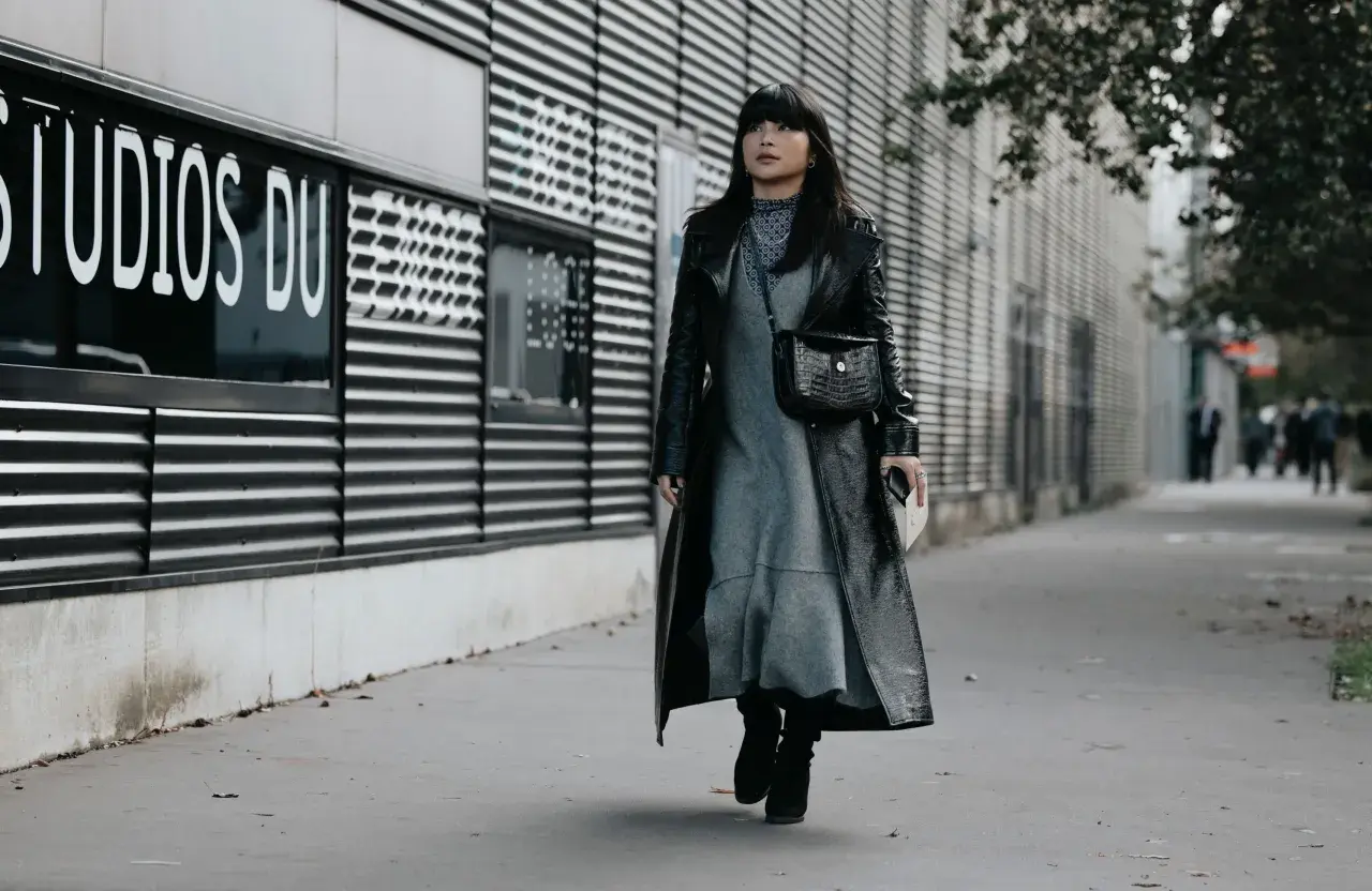 Une femme porte une robe grise et un long manteau noir verni, avec des bottines noires. Elle arbore un sac à main croco. Quelle chaussure mettre avec une robe noire et blanche ?