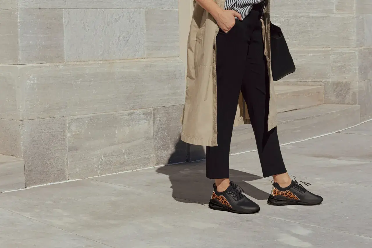 Quelles chaussures avec une combinaison noire ? Des baskets noires avec des détails léopard, parfaites pour un look chic et audacieux.