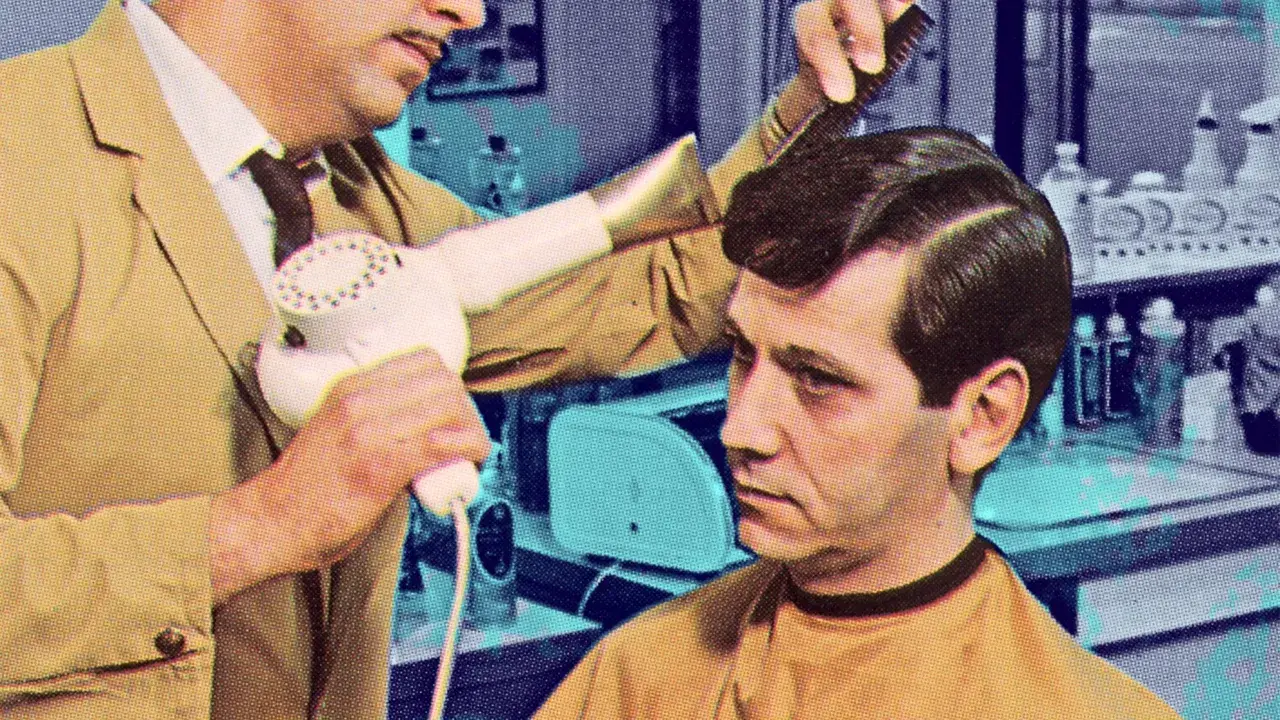 Coiffeur utilisant un sèche-cheveux pour **retendre du cuir** sur la coiffure d'un client.