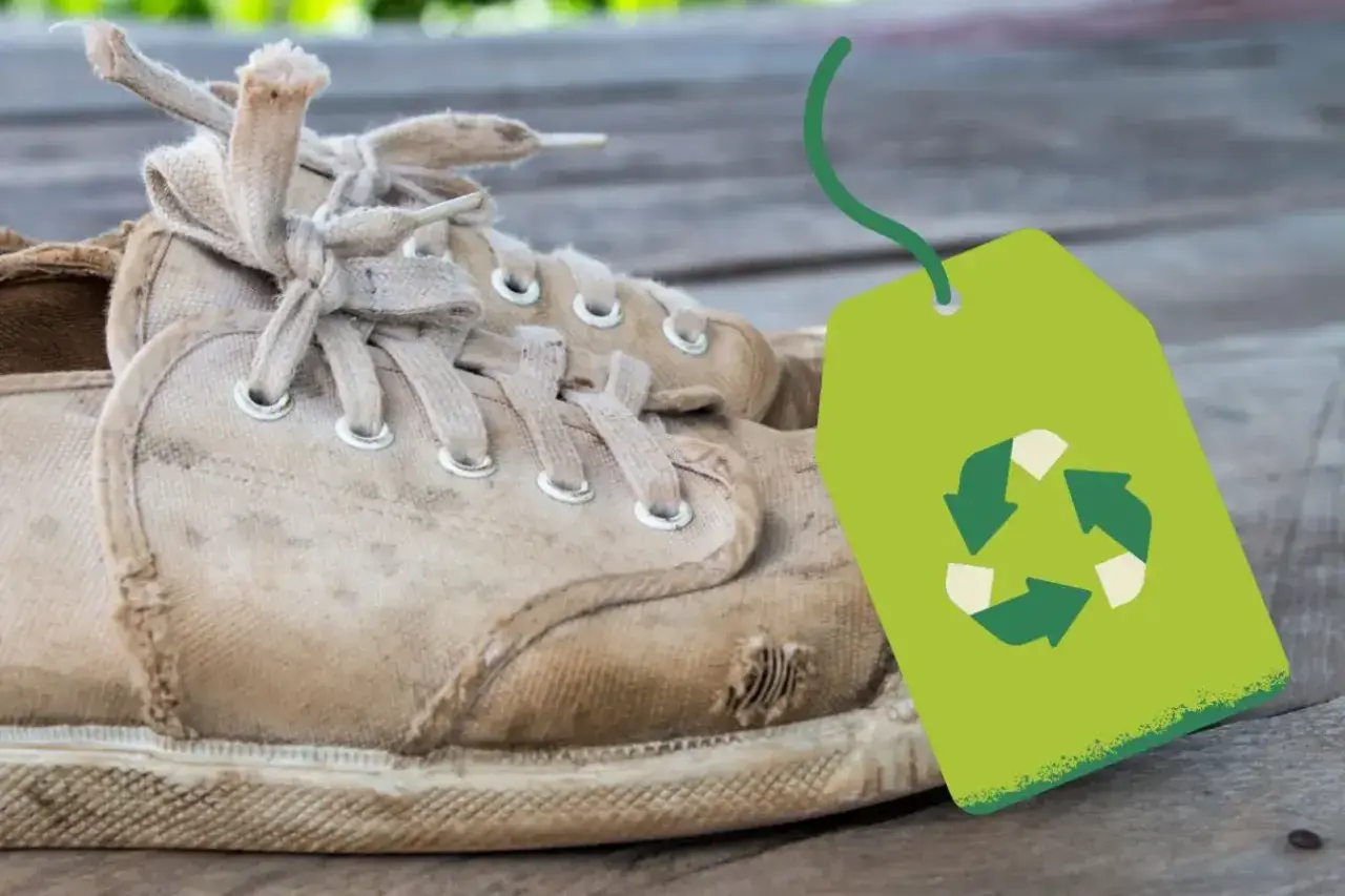 Vieilles baskets usées avec un symbole de recyclage vert. Une question se pose : où jeter des chaussures ?