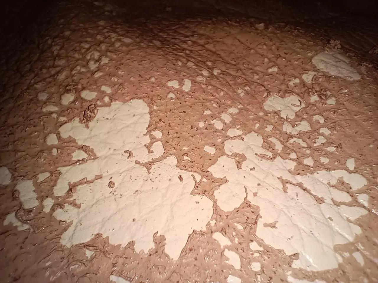 Texture de cuir décoloré par l'acétone, révélant des motifs abstraits et des zones claires.