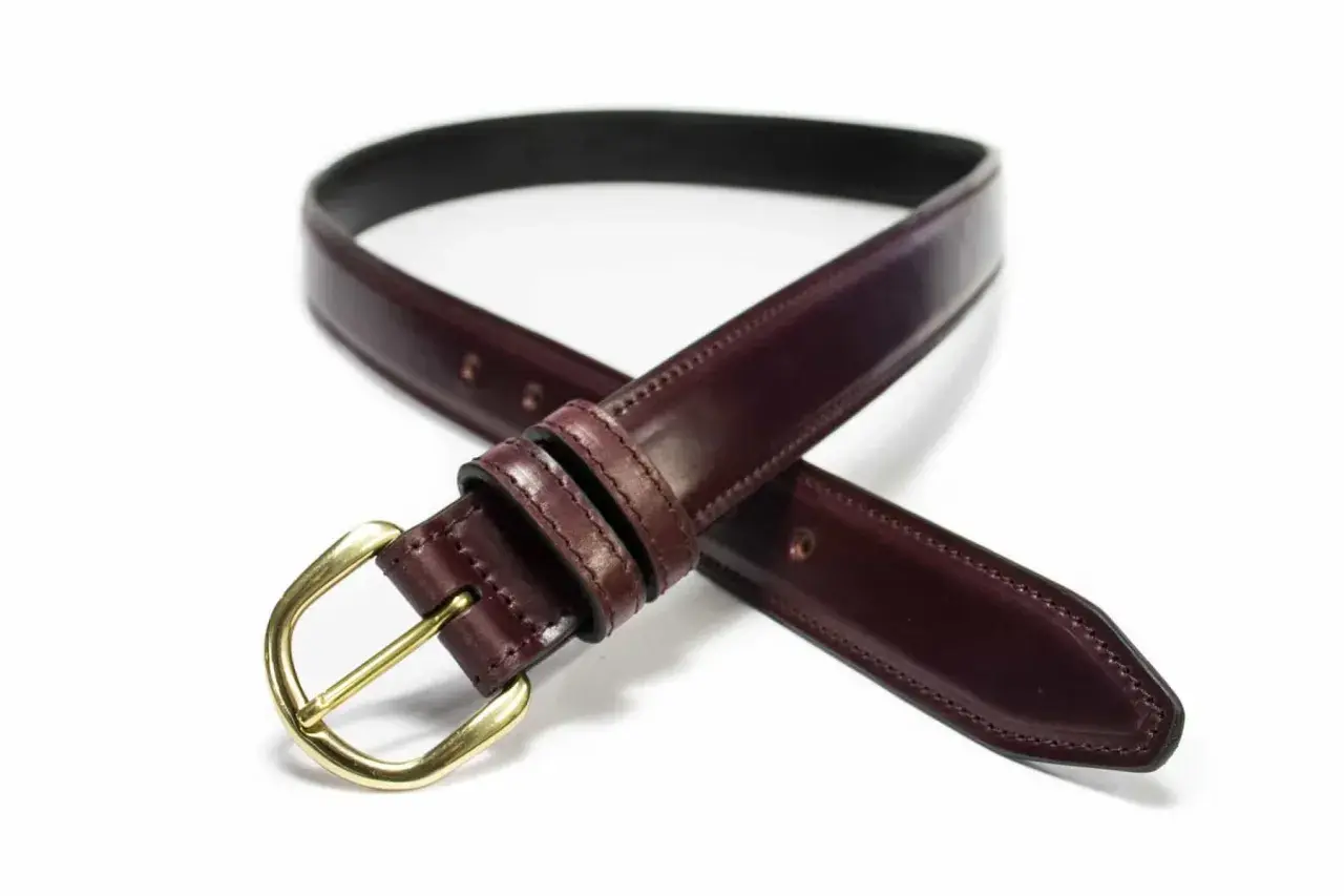 Ceinture élégante en cuir cordovan bordeaux avec boucle dorée, un accessoire intemporel pour parfaire votre tenue.
