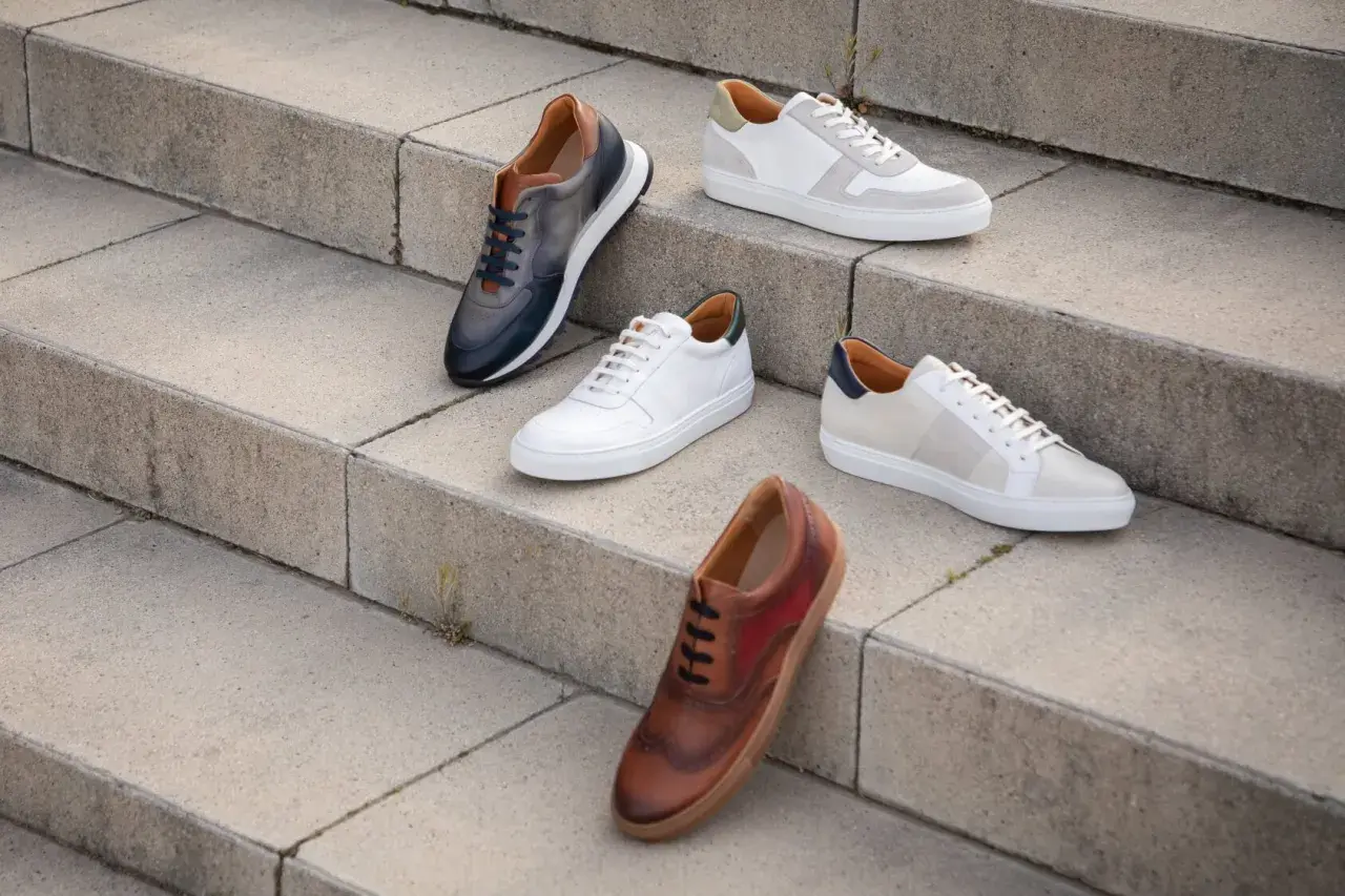 Cinq paires de chaussures élégantes, dont une tenue classe avec basket femme, sont disposées sur des marches en béton.