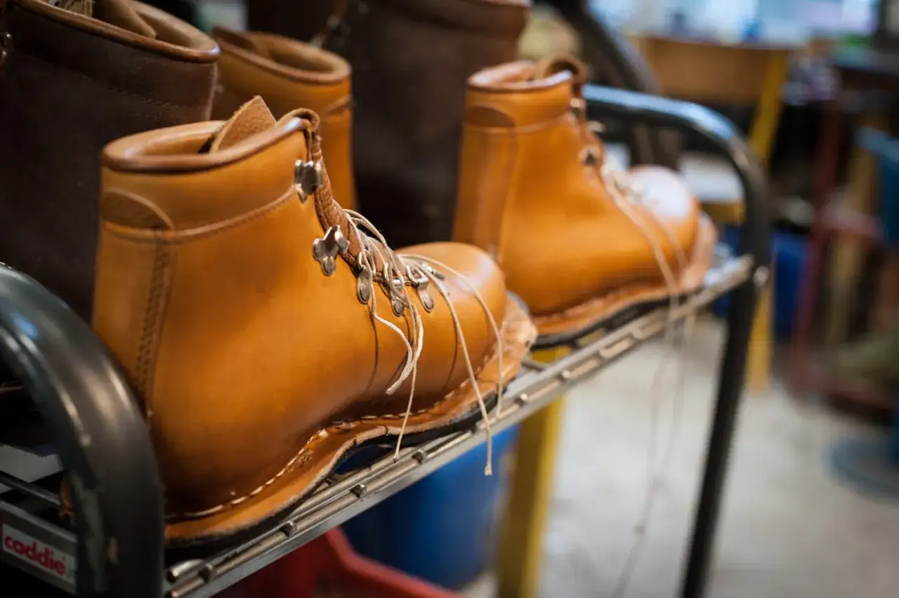 Des bottes en cuir marron clair, en cours de fabrication, montrent les étapes pour faire des chaussures.