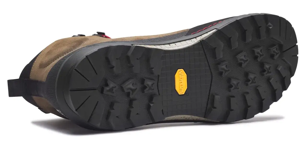 Semelle Vibram : c'est quoi ? La semelle ext&eacute;rieure crant&eacute;e d'une chaussure de randonn&eacute;e marron, avec le logo jaune Vibram bien visible.