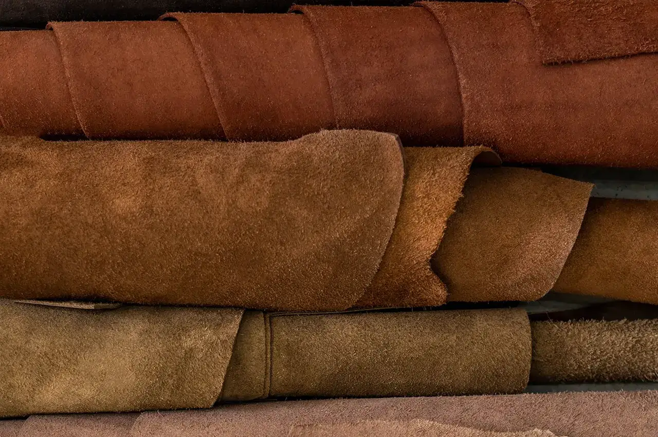 Superposition de rouleaux de cuir aux teintes brunes et ocres, &eacute;voquant la richesse et la qualit&eacute; cuir.