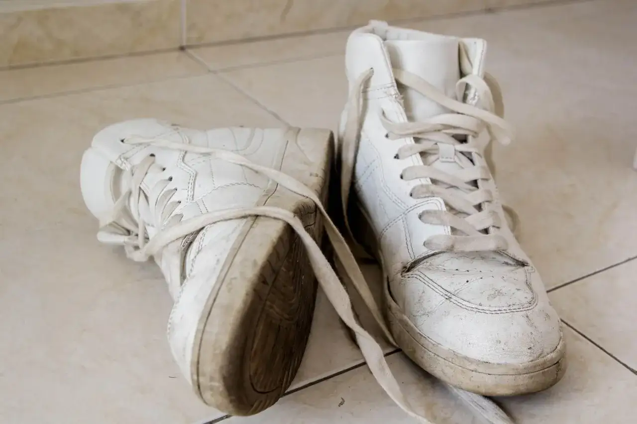 Paire de baskets montantes blanches, usées et sales, prêtes à blanchir la semelle pour leur redonner vie.