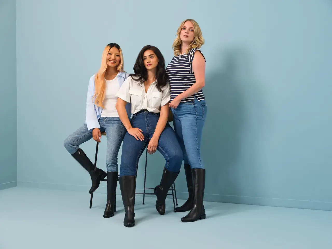 Trois femmes portent des bottes avec jean, un look décontracté et stylé.