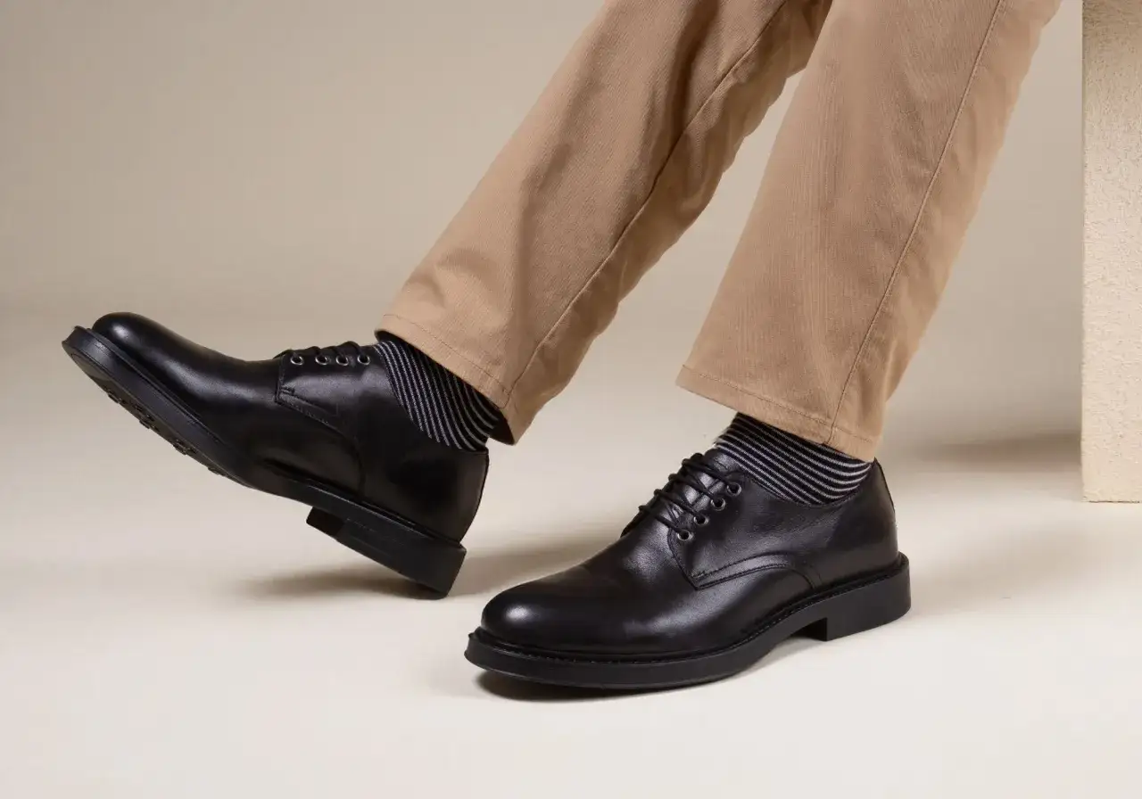Comment porter des derbies homme : un look casual chic avec un pantalon beige et des chaussettes rayées.