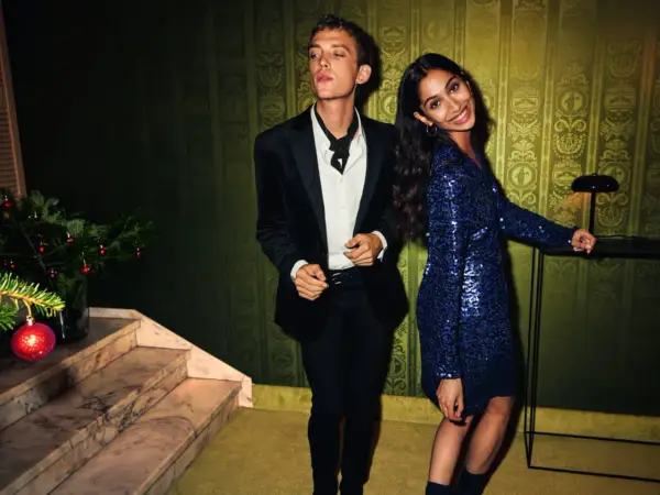 Un couple élégant, quelle tenue pour le réveillon du 31 ? Lui en smoking noir, elle dans une robe bleue à paillettes.